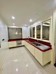 Modern kitchen with red countertops and beige cabinetry