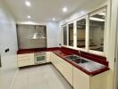 Modern kitchen with red countertops and beige cabinetry