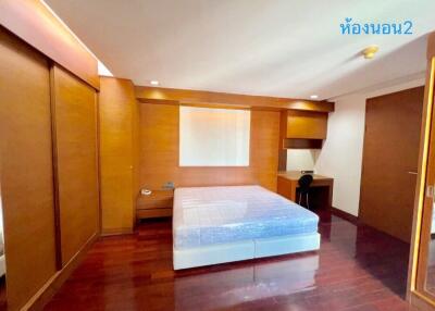 Spacious bedroom with wooden flooring and built-in wardrobes