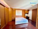 Spacious bedroom with wooden flooring and built-in wardrobes