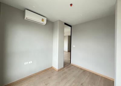 Empty bedroom with air conditioning and wooden floors