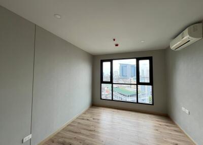 Empty bedroom with large window and air conditioner