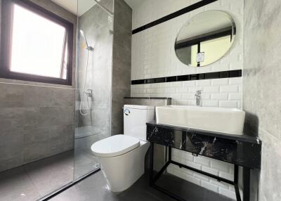 Modern bathroom with gray tiles and glass-enclosed shower