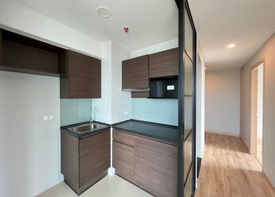 Modern kitchen with dark wood cabinetry and glass partition