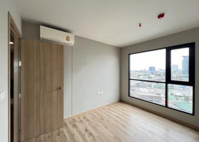 Empty bedroom with wooden floor, large window, and air conditioning unit