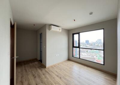 Empty bedroom with large window and city view