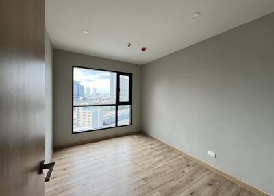 Empty bedroom with large window and wooden floor