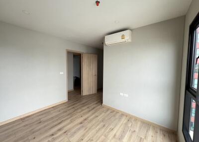 Empty bedroom with wooden floor and air conditioning