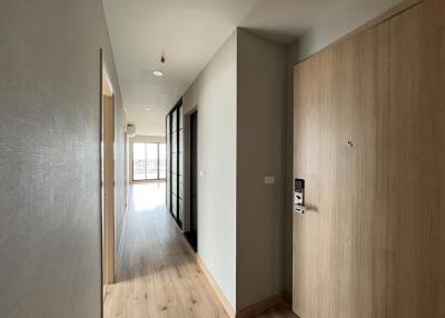 Bright hallway with wooden flooring leading to main living space