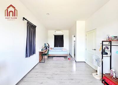 Spacious bedroom with desk and natural lighting