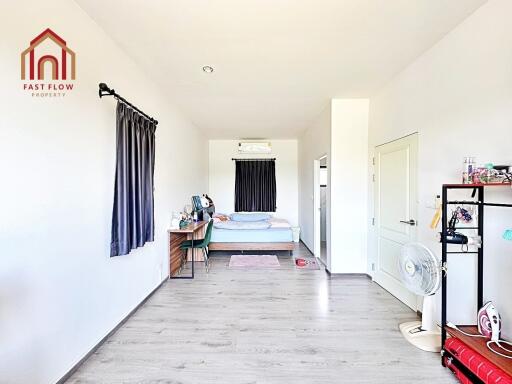 Spacious bedroom with desk and natural lighting