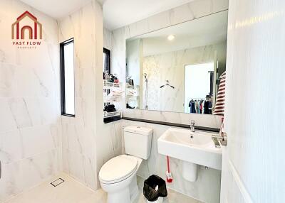 Modern bathroom with white fixtures and vanity mirror