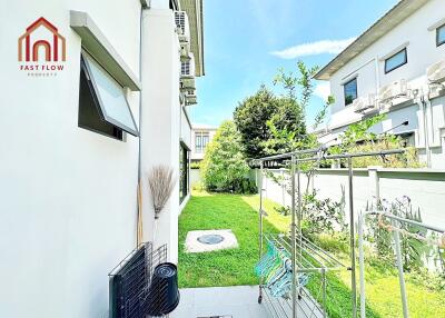 Side yard with green lawn and laundry drying area