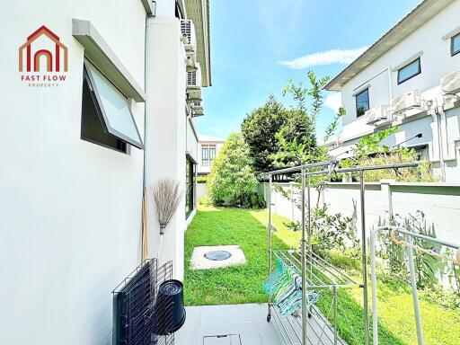 Side yard with green lawn and laundry drying area