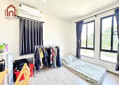 Bedroom with minimalist decor, natural light, and practical clothing storage