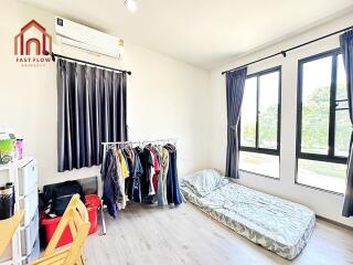 Bedroom with minimalist decor, natural light, and practical clothing storage