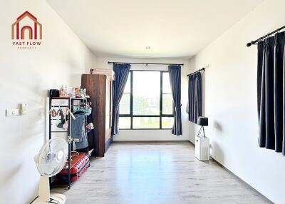 spacious bedroom with light wood flooring and large window