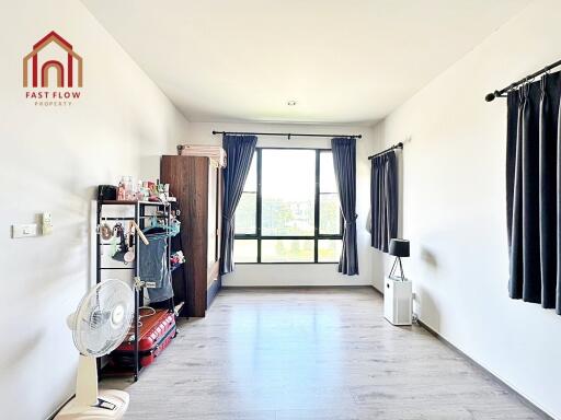 spacious bedroom with light wood flooring and large window