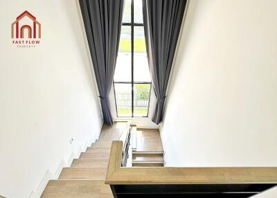 Modern staircase with large window and curtains