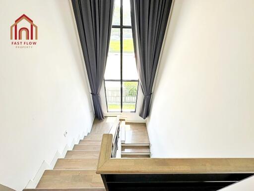 Modern staircase with large window and curtains