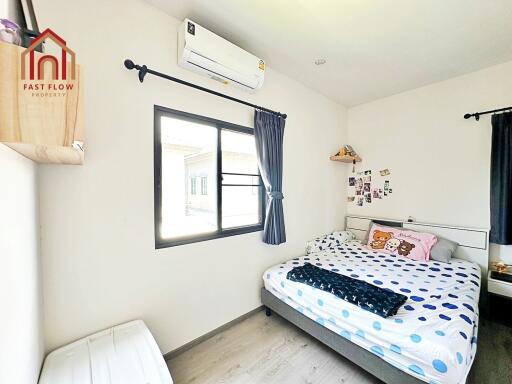 Cozy bedroom with double bed, window, and air conditioning