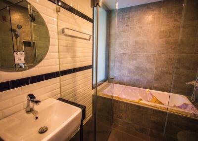 Modern bathroom with a sink, mirror, shower area, and bathtub