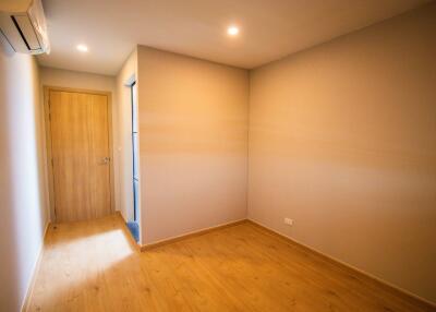 Empty bedroom with wooden floor and air conditioner