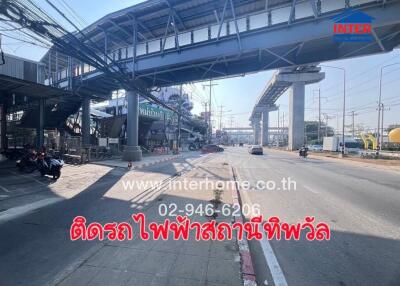 Street view with an elevated train track and building advertising