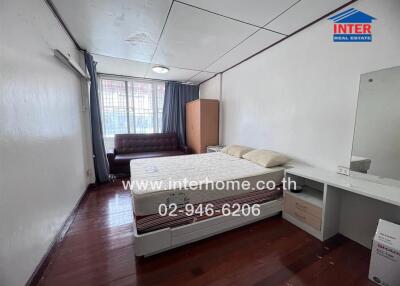 Spacious bedroom with bed, sofa, wardrobe, and dressing table