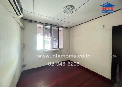 Empty bedroom with hardwood floors and a window