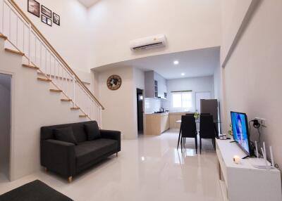 Modern living room with high ceiling and open kitchen