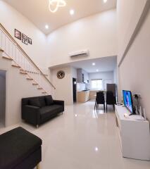 Modern living room with high ceiling and open kitchen