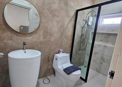 Modern bathroom with a pedestal sink and glass-enclosed shower