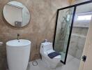 Modern bathroom with a pedestal sink and glass-enclosed shower