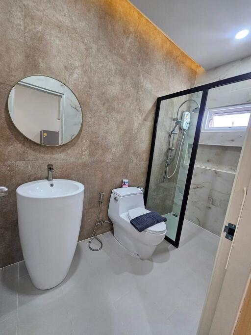 Modern bathroom with a pedestal sink and glass-enclosed shower