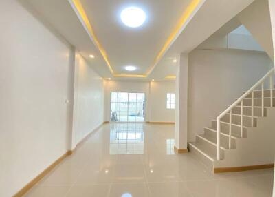 Spacious living room with modern lighting and staircase