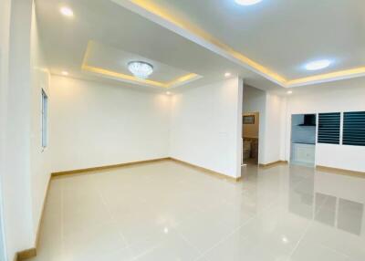 Spacious modern living room with large tiles and recessed lighting.