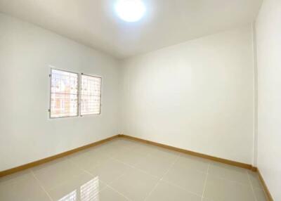 Empty bedroom with tile flooring and two windows with bars