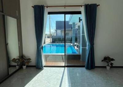 Living room with view of swimming pool and cityscape