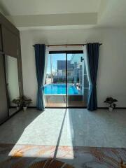 Living room with view of swimming pool and cityscape