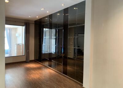 Modern living room with glossy black tiled wall and wooden flooring