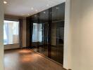 Modern living room with glossy black tiled wall and wooden flooring