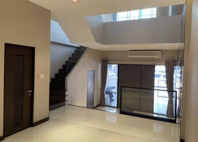 Modern living room with staircase and large windows