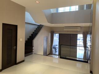 Modern living room with staircase and large windows