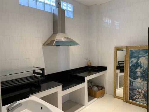 Modern kitchen with stainless steel hood and decorative artwork