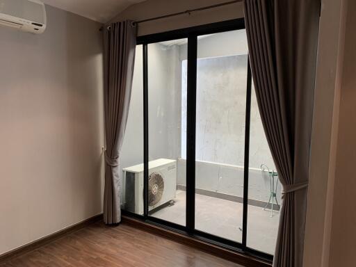 Living room with sliding glass doors leading to a small patio area