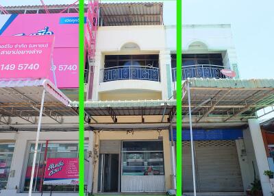 Front view of a commercial building with a balcony and roll-up doors