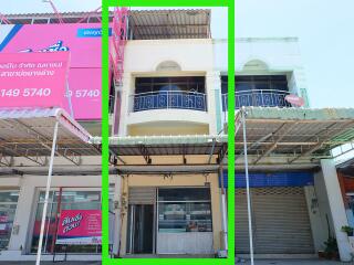 Front view of a commercial building with a balcony and roll-up doors