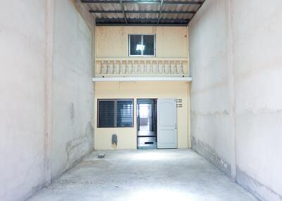 Interior of a partially-finished building with a mezzanine and a door