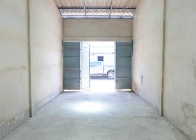 Spacious garage with open double doors and a pickup truck outside